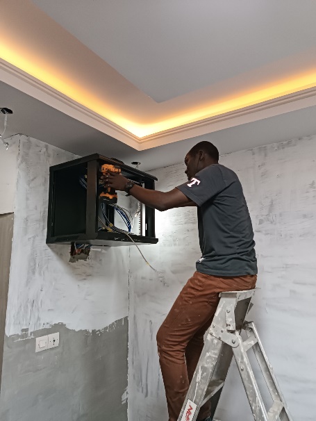 Technicien Guinée IT installant une baie réseau